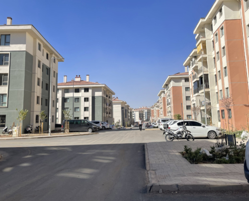 adiyaman5 Yeni inşa edilmiş çok katlı sosyal konut bloklarının dizildiği geniş bir sokak; "steril" bir kentsel yerleşim görünümü.